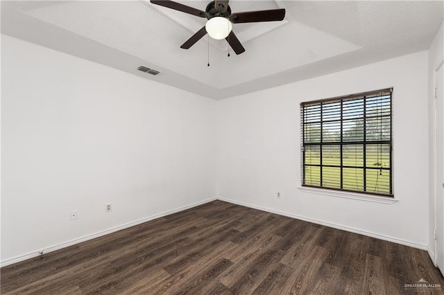 20538 Rio Rancho Rd, Harlingen, TX 78552 - spare room with dark wood finished floors, a tray ceiling, and a ceiling fan