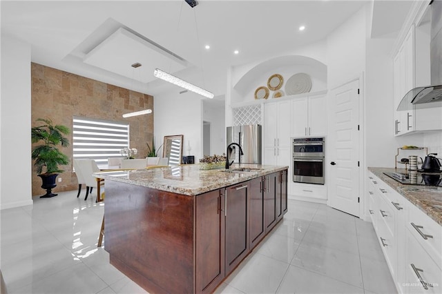 3408 Madison Ave, Edinburg, TX 78539 - kitchen with appliances with stainless steel finishes, wall chimney exhaust hood, white cabinets, light stone countertops, and hanging light fixtures