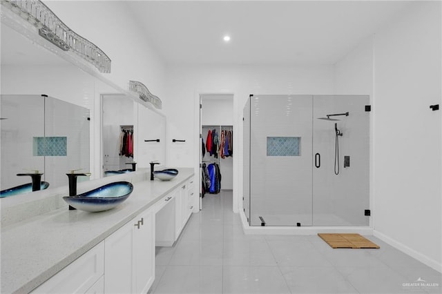 3408 Madison Ave, Edinburg, TX 78539 - bathroom featuring a walk in closet, a shower stall, double vanity, tile patterned floors, and recessed lighting