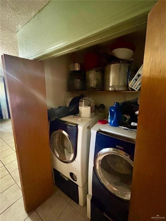 laundry room featuring washing machine and dryer and light tile patterned flooring