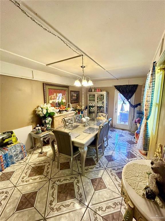 dining space featuring tile patterned floors and a notable chandelier