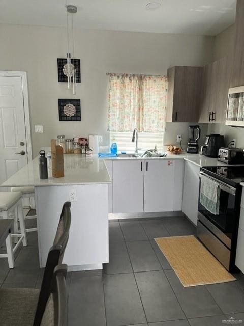 kitchen with pendant lighting, a center island, white cabinets, sink, and appliances with stainless steel finishes