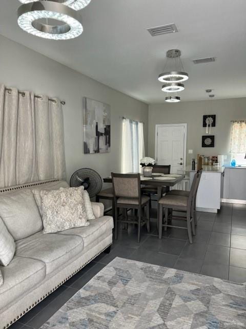 tiled living room with a notable chandelier