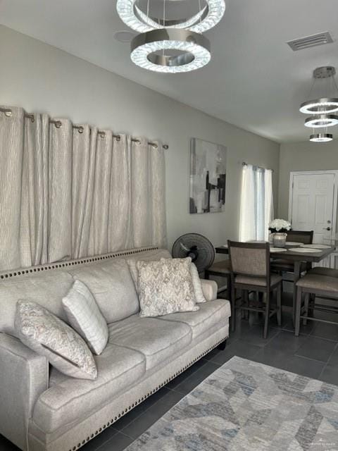 tiled living room with an inviting chandelier