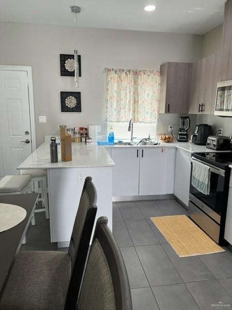 kitchen with white cabinetry, dark tile patterned floors, a kitchen island, and appliances with stainless steel finishes