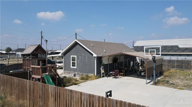 rear view of house featuring a carport and a playground