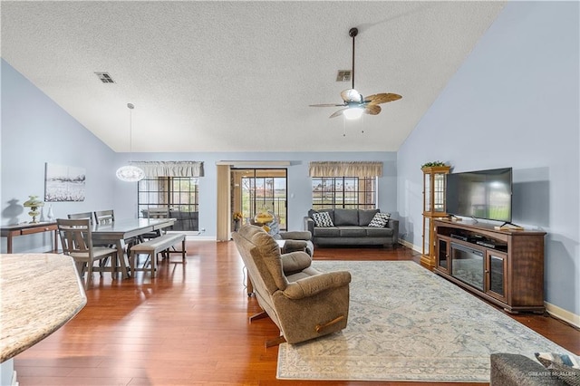 living room featuring wood finished floors, visible vents, and a ceiling fan