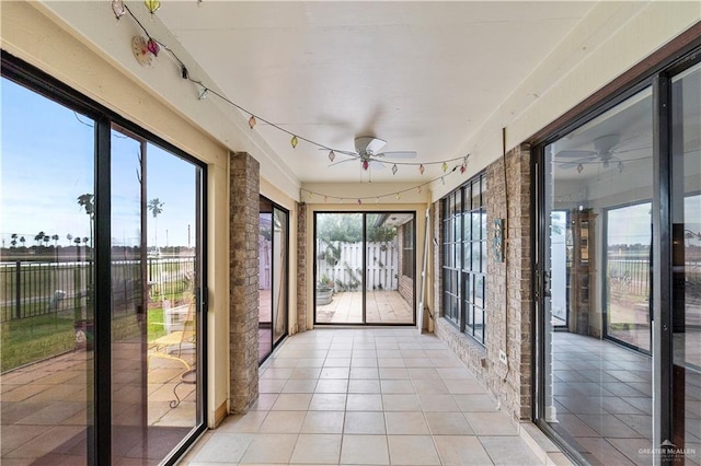 unfurnished sunroom with a ceiling fan