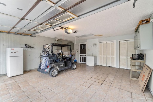 garage featuring a garage door opener and freestanding refrigerator