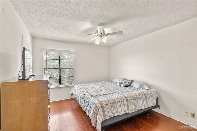 bedroom featuring a textured ceiling, ceiling fan, wood finished floors, and baseboards