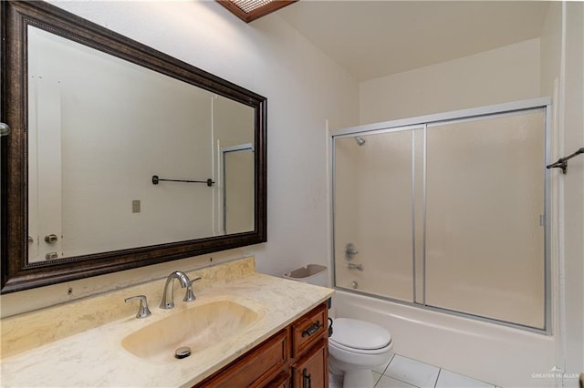 bathroom with tile patterned flooring, shower / bath combination with glass door, vanity, and toilet