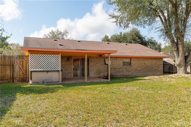 rear view of property with a patio area, fence, a lawn, and brick siding