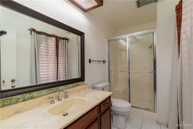 bathroom with tile patterned flooring, toilet, vanity, visible vents, and a stall shower