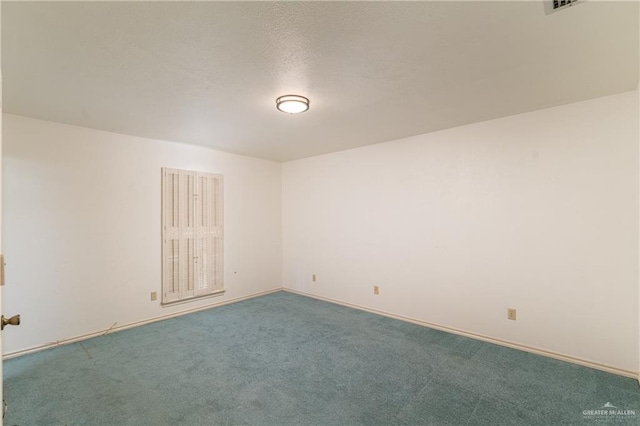 empty room featuring a textured ceiling, carpet, and baseboards