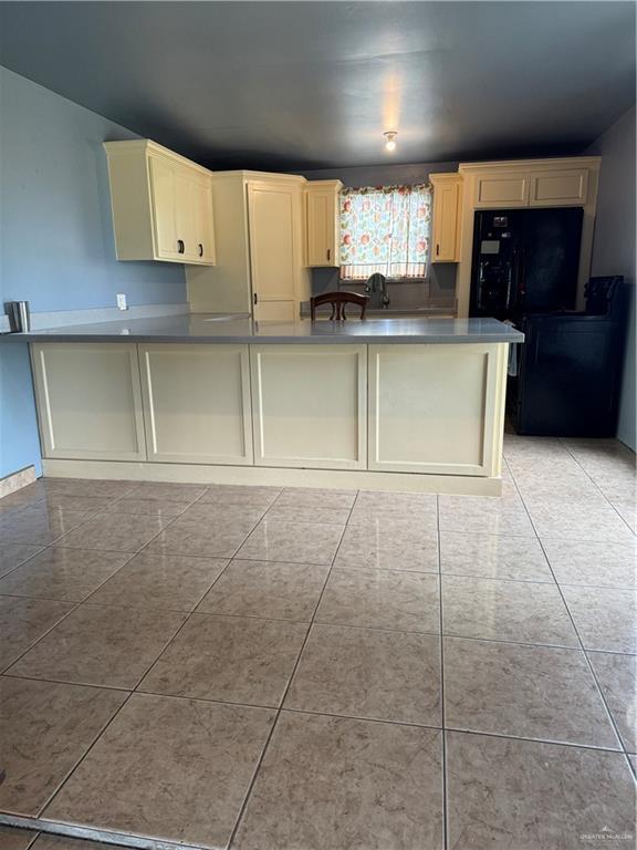 4512 Devon St, Mercedes, TX 78570 - kitchen with a peninsula and light tile patterned floors