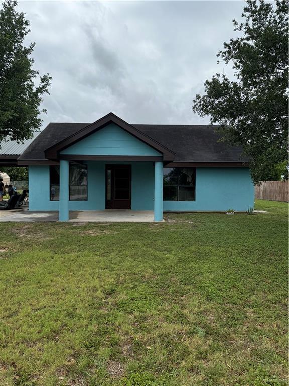 4512 Devon St, Mercedes, TX 78570 - view of front facade with covered porch, roof with shingles, fence, and a front yard
