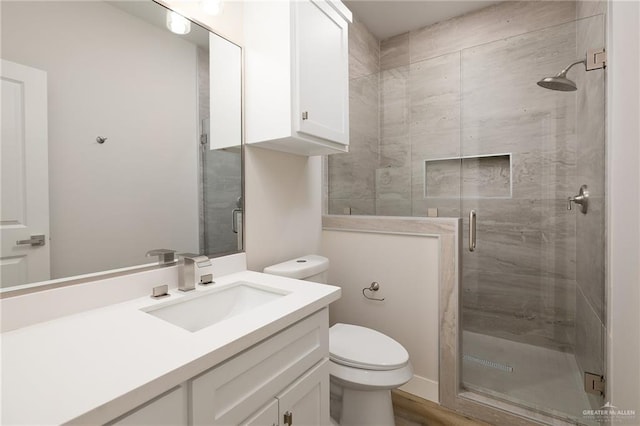 bathroom with walk in shower, vanity, and toilet