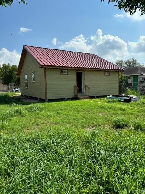 rear view of property featuring a lawn