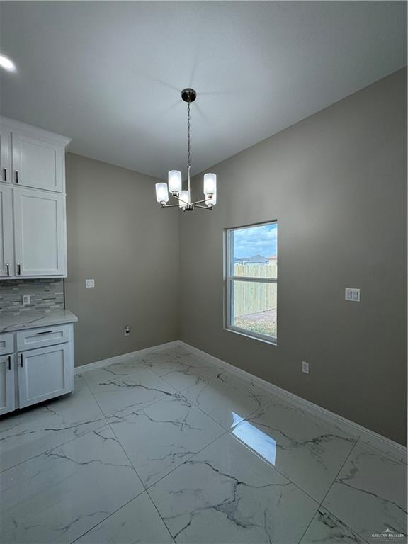 unfurnished dining area featuring an inviting chandelier