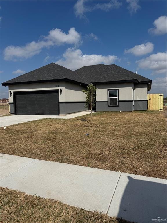 prairie-style house featuring a garage and a front yard