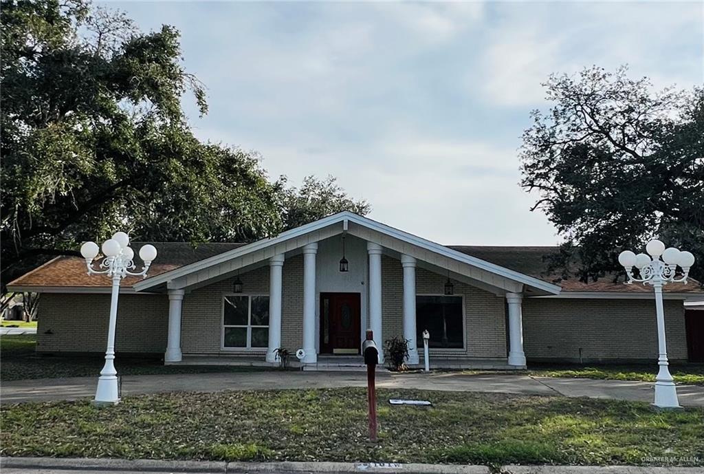 view of front of home with brick siding and a front yard