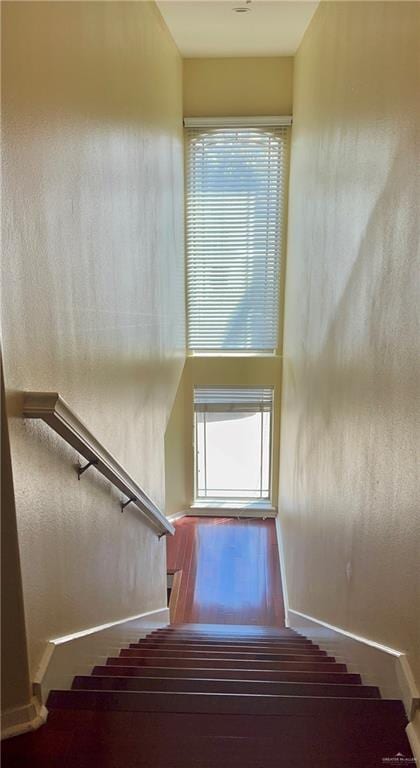 staircase featuring a wealth of natural light and wood-type flooring