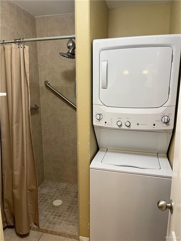 clothes washing area featuring light tile patterned flooring and stacked washer / drying machine