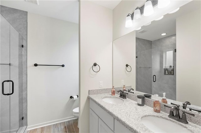 bathroom with hardwood / wood-style flooring, vanity, toilet, and walk in shower