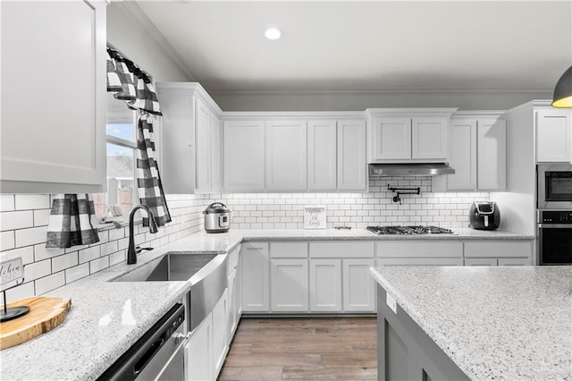 kitchen featuring white cabinets, ornamental molding, and appliances with stainless steel finishes