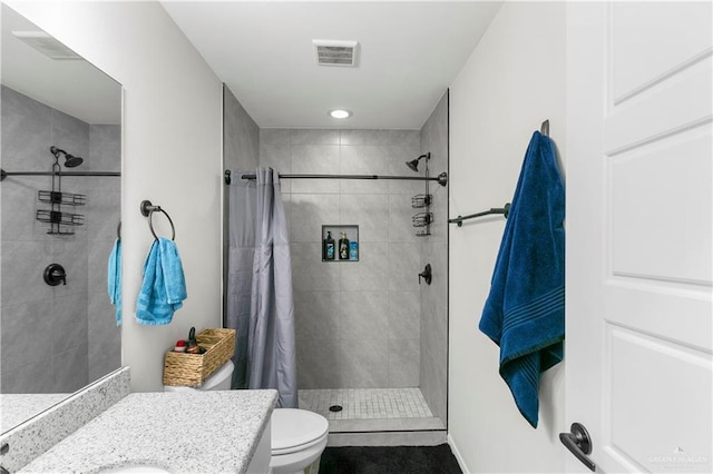 bathroom featuring toilet, vanity, and walk in shower