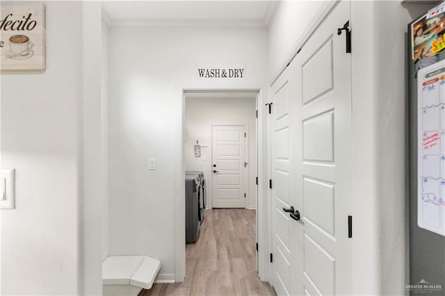 hall featuring light hardwood / wood-style flooring, washer and clothes dryer, and crown molding