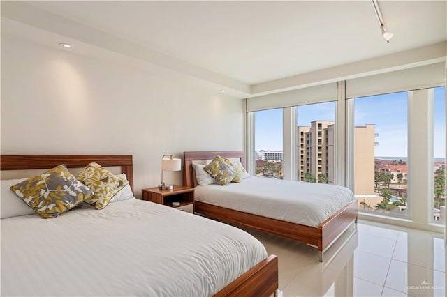 tiled bedroom featuring track lighting