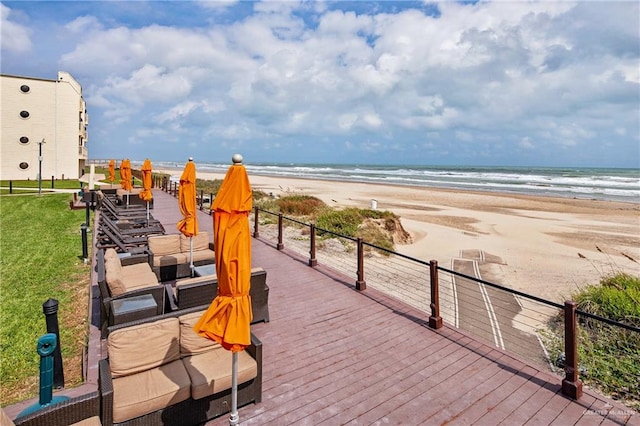 view of property's community with a view of the beach, an outdoor hangout area, and a deck with water view