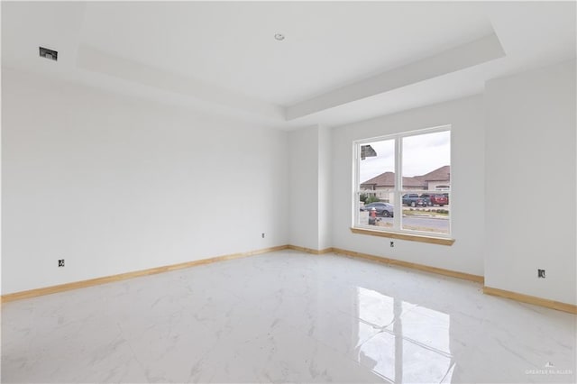 unfurnished room with a raised ceiling