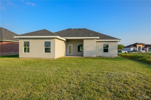 rear view of house with a lawn and a patio area