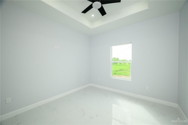 unfurnished room with a tray ceiling and ceiling fan