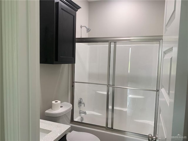 full bathroom featuring enclosed tub / shower combo, vanity, and toilet