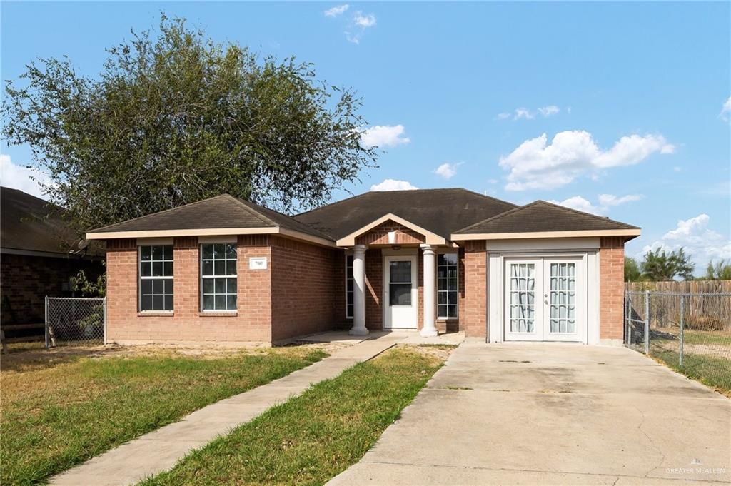 single story home with a front lawn and french doors