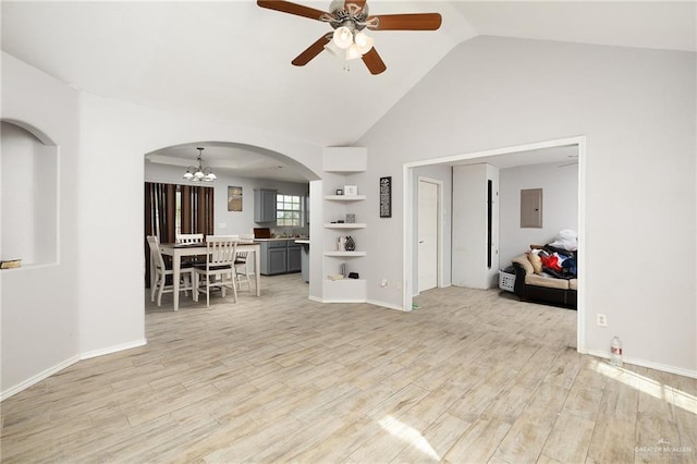 living room with ceiling fan with notable chandelier, electric panel, light hardwood / wood-style flooring, and high vaulted ceiling