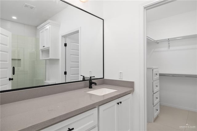 bathroom with tile patterned floors, a shower with door, vanity, and toilet