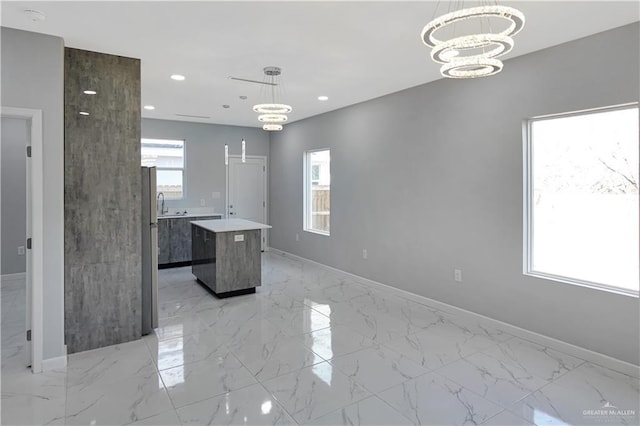 kitchen featuring a chandelier, a center island, marble finish floor, and recessed lighting