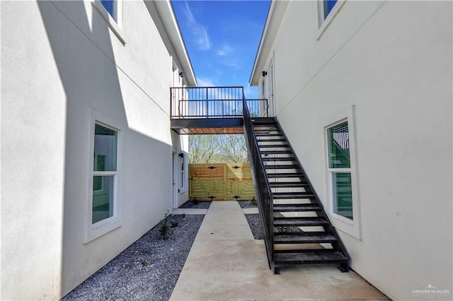 view of side of home with stairs and stucco siding