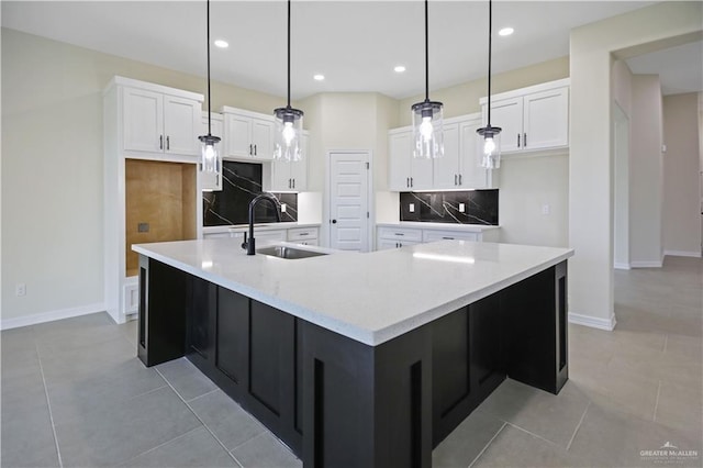 kitchen featuring a large island, sink, decorative light fixtures, and tasteful backsplash