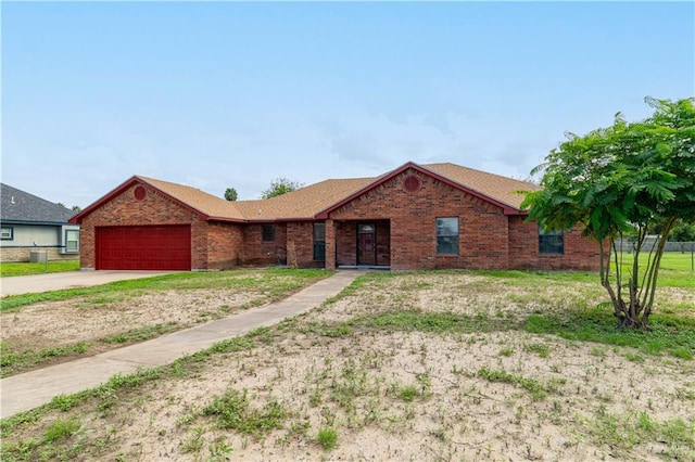 ranch-style home with a garage, concrete driveway, and brick siding