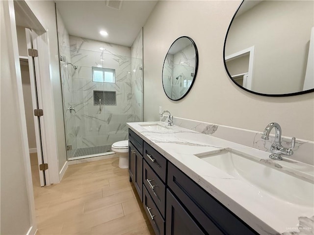 bathroom featuring vanity, a shower with shower door, and toilet