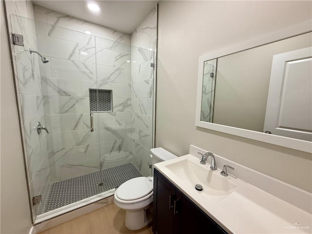 bathroom with vanity, a shower with shower door, and toilet