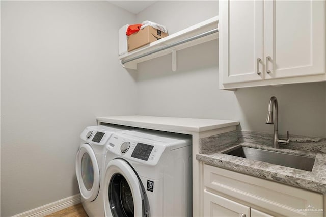 washroom with separate washer and dryer, sink, cabinets, and light hardwood / wood-style floors