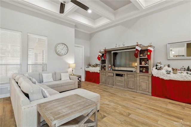 living room with coffered ceiling, ceiling fan, light wood-type flooring, ornamental molding, and beam ceiling