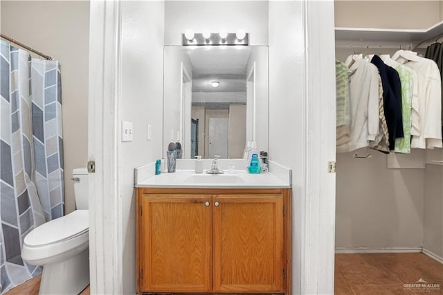 bathroom featuring tile patterned floors, vanity, and toilet