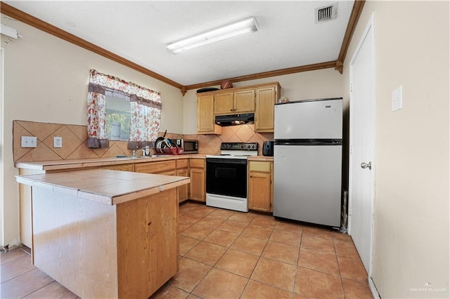 kitchen with appliances with stainless steel finishes, backsplash, ornamental molding, light tile patterned floors, and tile counters